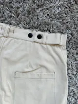 Bermuda de jean color crudo con detalles en negro, tiro alto y ajuste en la pretina.