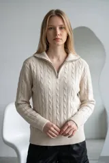 Sweater de punto gris con diseño de ochos verticales, cuello alto con cierre frontal y mangas largas con puños acanalados.