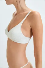 Corpiño blanco sin aro, de microfibra jacquard con diseño floral. Las tazas tienen doble tela para mayor sostén y un performado que moldea el tejido.