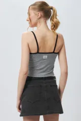 Top ajustado al cuerpo con estampado a cuadros blancos y negros, breteles finos y ribete negro en escote y sisas.