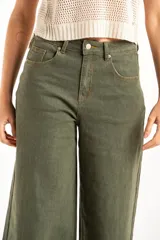 Pantalón wide leg de tiro medio en color verde oliva, confeccionado en tejido de algodón con mezcla de poliéster, liocel y elastano. Presenta diseño de cinco bolsillos, cierre frontal con botón y cremallera, y costuras a tono.