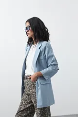 Blazer de jean color celeste con silueta recta y corte sastrero. Presenta solapas clásicas, cierre frontal con botón forrado, bolsillos con tapa y detalle de botones forrados en los puños.