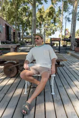 Remera tejida color crudo con cuello redondo con borde verde, mangas cortas y bolsillo en el pecho. Corte holgado.