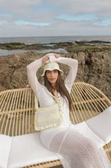 Cartera tejida a crochet con hilo 100% de algodón. Diseño a rayas horizontales en tonos de rojo y rosa, con volados en el borde y en el asa.