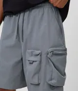 Bermuda baggy cropped de color beige, confeccionada en poliéster, con bolsillos cargo laterales y cintura elástica.