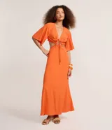 Vestido largo naranja de lino y viscosa, con escote en V profundo, mangas amplias, lazo delantero y recortes laterales en la cintura.
