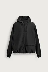 Cazadora relaxed fit de tejido técnico negro repelente al agua, con interior de forro polar, capucha ajustable, cierre frontal de cremallera y bolsillos frontales con solapa.