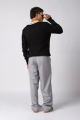 Sweater de punto acanalado en color negro, con cuello polo en contraste color crema. Presenta detalles bordados en el pecho y estampado tipográfico central con la frase 'Concept ALL GOOD FEELS'.