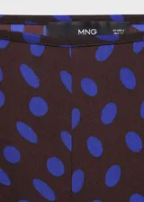Pantalón de tiro medio con diseño flare y largo, con cierre de cremallera lateral y estampado de lunares.