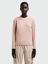 Buzo rosado de microtejido suave con cuello redondo y puños negros.