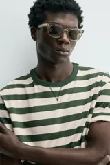 Camiseta relaxed fit de manga corta con cuello redondo, confeccionada en tejido de algodón con estampado de rayas horizontales verdes y beige.