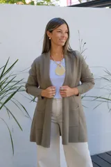 Saco tipo cárdigan abierto de punto fino en color verde oliva, con mangas largas y bolsillos frontales aplicados.