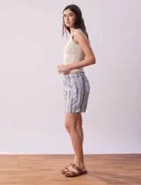 Short color crema con finas rayas verticales grises, pretina elastizada con cordón de ajuste, bolsillos delanteros y traseros.