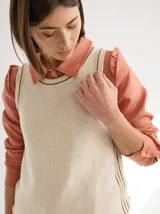 Camisa de lino color negro, con cuello clásico, cierre frontal de botones de madera y detalle de volados en los hombros. Presenta costuras a la vista en tono contrastante.