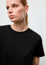 Camiseta básica de algodón color negro, con mangas cortas y cuello redondo.