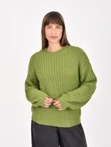 Buzo de tejido de punto grueso en color verde, con cuello redondo, mangas largas y corte holgado.