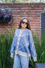 Saco tejido de punto con diseño geométrico de rombos en color azul y blanco. Presenta cuello redondo, cierre frontal con botones, mangas largas abullonadas y terminaciones acanaladas en puños y ruedo.