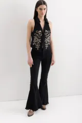 Pantalón de jean negro acampanado con terminación desflecada.