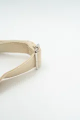 Cartera tipo bandolera de tela con diseño semicircular, cuenta con una correa larga ajustable y cierre superior.