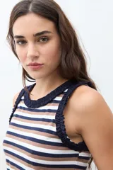 Top sin mangas a rayas horizontales en tonos azul marino, blanco y marrón, con detalle de volados en el cuello y las sisas.