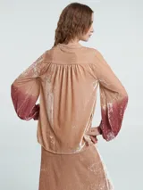 Blusa verde esmeralda de terciopelo con escote en V y mangas largas abullonadas con degradé a negro en los puños.