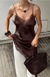 Vestido midi slip dress color marrón, de satén con tirantes finos y detalles de encaje en el escote y el dobladillo asimétrico.