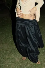 Pantalón negro de corte amplio y voluminoso, con cintura ajustable y diseño estilo babucha o bombacho.