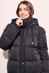 Tapado negro largo con capucha, diseño capitoneado y cierre frontal con botones dorados.