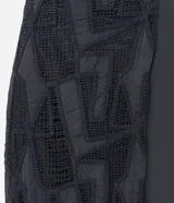 Salida de playa tipo pollera midi con superposición de laise con formas geométricas abstractas, confeccionada en algodón BCI.