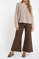 Sweater de punto texturado en color bordó con destellos de lurex, de corte holgado, cuello redondo y mangas largas.