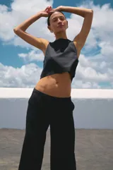 Top corto negro de lino y rayón, con escote redondo y corte recto.