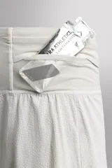 Short deportivo de trail running confeccionado en tejido técnico elástico con textura. Presenta una cintura elástica ancha con compartimentos integrados, bolsillo trasero con cierre y aberturas laterales en el bajo.