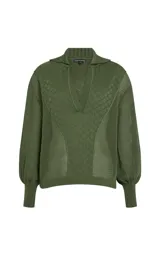 Sweater de punto color verde militar, con cuello polo y escote en V, mangas largas abullonadas con puños ajustados y tejido con tramas geométricas combinadas.