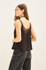 Top tipo musculosa de modal satén color crema, con detalle de encaje calado y bordados a tono en el escote delantero y en la espalda.