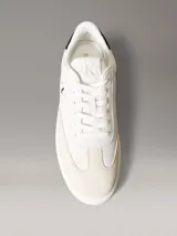 Zapatillas de ante Calvin Klein de color blanco, con detalles en contraste negro en el talón e inserciones de ante en la puntera. Cuentan con cordones blancos, suela de goma y el monograma de la marca en el lateral y la lengüeta.