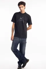 Remera de algodón color negro, con cuello redondo y mangas cortas. Presenta un estampado frontal con una estrella azul y un delfín en el centro, acompañado de tipografía estilo gótico.