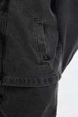 Campera de denim color gris oscuro con lavado washed, cierre metálico frontal y bolsillos delanteros, de diseño clásico.