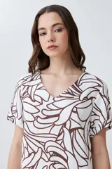 Vestido corto de lino color blanco con estampa abstracta en color chocolate, escote en V y mangas cortas.