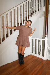 Vestido corto color verde oliva, de manga corta y corte holgado con frunce en la cintura que genera un efecto de falda globo (balloon).