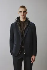 Blazer de corte regular fit confeccionado en tejido técnico y transpirable de color negro, con cuello de solapas de muesca, cierre frontal de un botón y bolsillos con solapa en la cadera.