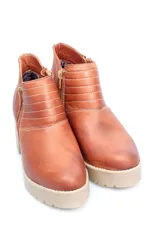 Botín negro de cuero con cierre metálico lateral, costuras decorativas y suela track con plataforma.