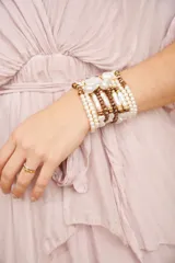 Brazalete de múltiples vueltas con perlas blancas y cuentas doradas.