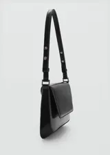 Bolso negro con efecto piel, asa ajustable y cierre de clip metálico. Tiene tamaño medio, asa de hombro y forro interior.