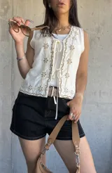 Chaleco blanco con bordado de flores color beige, con escote en V y cierre frontal con lazos.