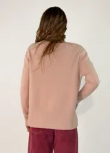 Sweater de punto color negro, con cuello redondo, manga larga y diseño con costura central vertical. Presenta un dobladillo acanalado en la cintura y puños, con un largo asimétrico siendo más corto en la parte delantera y más largo en la parte trasera.