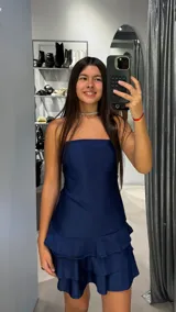 Vestido corto azul marino con escote strapless y diseño de tres volados superpuestos en la falda.
