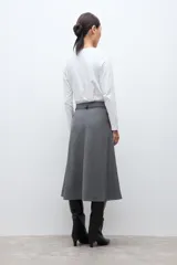 Falda midi de corte acampanado con estampado de cuadros pequeños en tonos grises. Presenta un diseño de tiro alto y estructura firme.