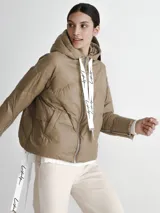Campera puffer color visón con capucha y cierre frontal con cremallera. Presenta cordones blancos con letras negras en la capucha y en los puños.
