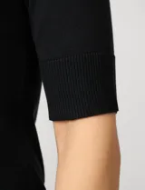 Buzo de tejido fino en color azul marino, con cuello redondo y mangas cortas con puños acanalados.