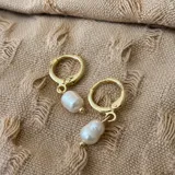 Aros abridores tipo argolla dorados con un dije colgante de perla de río barroca.
